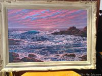 Framed full view of seascape painting showing waves, rocks, and sky.