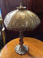 Full view of lamp showing brass base, stem and slag glass shade