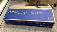 Sealed retail box showing Samsung UHD Monitor branding and model UJ59 labeling