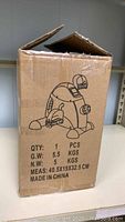 Closed cardboard box with simple black line drawing of the portable exercise bike on the front with weight and size dimensions.