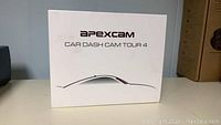 White box front showing brand and model 'Apexcam Car Dash Cam Tour 4' with stylized car outline graphic.
