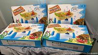Four boxed Beach Toys Model 16883 sets stacked showing packaging and branding