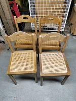 Four wooden cane-seated chairs arranged in two rows, showing overall condition and design.