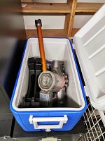 Top-down view of Coleman cooler containing Dyson V8 Absolute vacuum and accessories