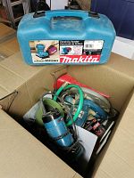 Overview of lot in cardboard box showing Makita sander case and loose tools