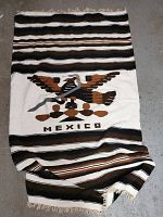 Full view of the woven tapestry showing eagle motif, stripes, and fringed edge.