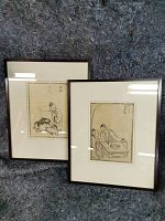 Pair of framed oriental woodblock prints with Asian characters and traditional figure drawings.