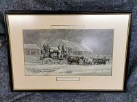 Full view of the first framed print depicting a stagecoach in snowy landscape, shows frame style and matting.