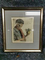 Framed etching displayed against a dark surface illustrating the full piece including frame and matting.