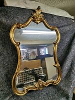 Full front view of gilt-framed mirror showing overall shape and design.