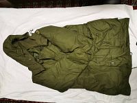 Green Canadian military extreme cold weather parka laid flat, showing full length, button and snap closures, and hood.