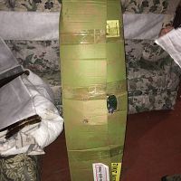 Photo of the rectangular green cardboard box containing the folded 7-foot Oregon Pine slim lighted Christmas tree showing the condition of the box and storage method.