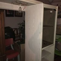 Side view of the cabinet showing the wood finish and partial internal shelving.