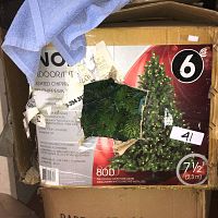 Cardboard box packaging for 7.5 foot artificial Christmas tree with Noma brand, displaying product image and key features.