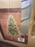 Label on the box shows this is a 7.5 feet pre-lit Koster Spruce Tree with 100 clear lights, 58 inch girth and includes spare bulbs.