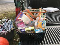 Wide view showing the tote bag filled with various personal items on a truck bed.