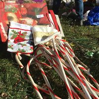 Candy cane decorations, Christmas-themed fabric pieces with cardinal and gold embellished design on grass