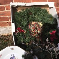 Large and small Christmas wreaths, porcelain plate with fruit design partially visible