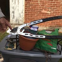 Overall lot view showing large Fiskars shears on top of flower pots and garden flag