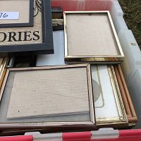 A full tote box with an assortment of picture frames visible, showing different frame styles and sizes stacked inside.