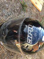 Top-front angled view showing the visor, HJC logo, and black glossy finish with some wear and scratches.