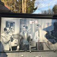 Framed black and white picture of The Rat Pack with Dean Martin, Frank Sinatra, Sammy Davis Jr., and Burt Lancaster around a pool table, some glare from sunlight visible.