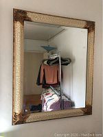 Full view of rectangular wall mirror showing the crackle finish frame and beveled glass reflecting room interior.