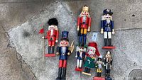 Various wooden nutcrackers laid on concrete surface showing overall lot condition and size variation