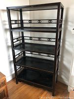 Full front view of one bookcase showing overall structure, four tiers, and decorative double-ring fretwork rails