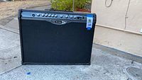 Front and side view of the black Line 6 Spider 2 guitar amplifier unit placed outdoors.