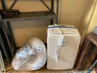 Front of LG unit alongside vent hose in plastic bag