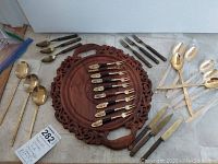 Overview of lot showing flatware and wooden tray.