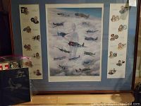 Framed art print showing WWII fighter planes over clouds with blue matte and wood frame, surrounded by illustrated pilot portraits
