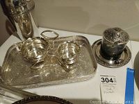Photo showing the full serving set including the large engraved tray, two silver bowls on stand, and the ornate covered jar with underplate.
