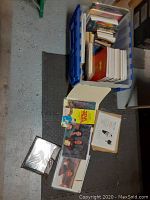 Top view of plastic container filled with Star Trek books, blueprints and photos laid out on floor