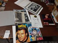 Overview photo of binders, magazines, signed sketch, and photo cards on table