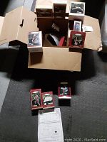 Photo showing open box with multiple Hallmark Star Trek Christmas ornaments in original red and white boxes and instruction sheet.