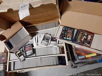 Wide view of large quantity of Star Trek trading cards partially boxed and loosely scattered in storage boxes.