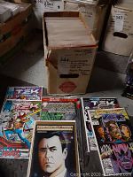 Box of comic books with multiple visible titles including TekWorld and Star Trek Deep Space Nine