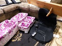 Five white wicker baskets with purple floral liners and black back massager chair on carpeted floor near couch
