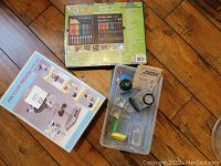 Photo of microscope set box, kids science tools in plastic tray, and boxed kids art set showing front of box