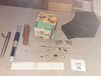 Photo showing all lot items including the slide rule, jewelry boxes, physics tube with leather case, and small scattered items.