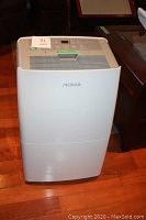 Front view of white Noma dehumidifier on wood floor