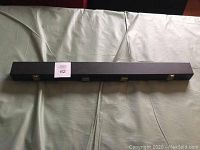 Closed black rectangular hard case with silver latches and a note number 62 on top, showing the exterior of the case for the pool cue.