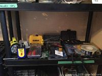 Shelf with tools including flashlight, tester, carrying case, and hardware boxes