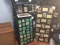 Two large collage photo frames displayed leaning against shelves and furniture. One frame has multiple circular, oval, and rectangular photo slots; the other has rectangular openings with white corner protectors.