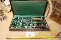 Boxed carving set with stag antler handles inside a satin-lined wood case on a table, including knife, fork, and sharpener.
