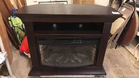 Front view of dark espresso wood electric fireplace console with open media shelf and curved glass insert