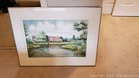 Framed lithographic art showing a scenic view of Eton with a building, river, and trees in detailed color.