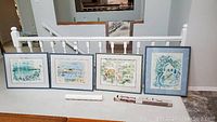 Four signed and framed Birdsey prints displayed side by side with different coastal and landscape scenes.